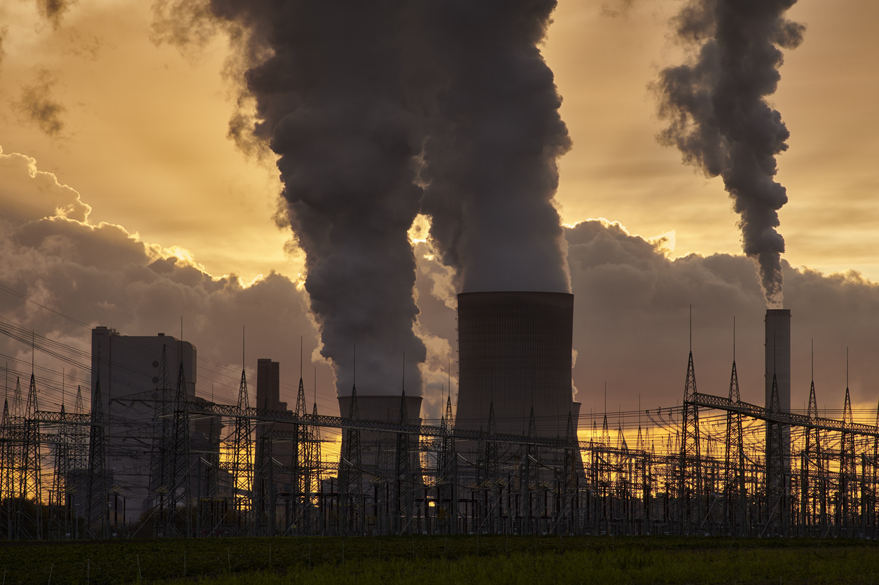 Silhouette of a power plant with pollution and an electricity substation